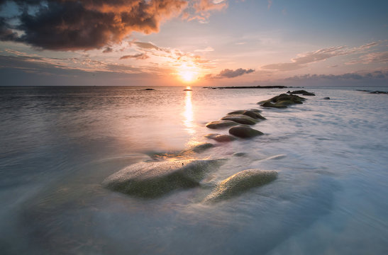 sunset over green leading line rock