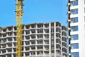 Crane and building construction site against blue sky