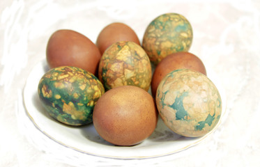 Obraz na płótnie Canvas Colorful Easter eggs on white plate placed by heap