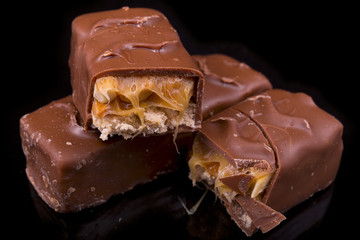 slices of Snickers bars on a black background macro