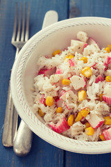 fish salad on white bowl on blue wooden background
