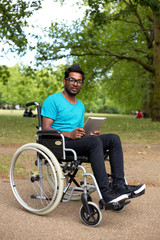 young man in a wheelchair using a tablet computer