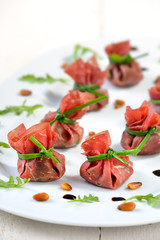 Leckere Schinkensäckchen aus Bresaola, gefüllt mit Rucola, gerösteten Pinienkernen, Parmesan und Crema di Balsamico