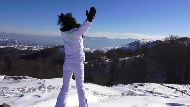 Hands raised Girl on the snow mountain 
