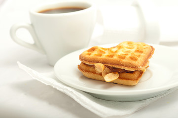 cup of morning coffee and fresh waffles in the shape of heart on