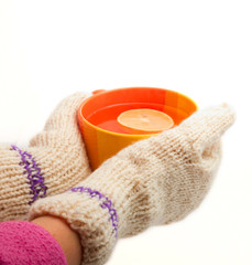winter cup of tea in  hands in warm mittens separately on a whit