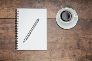 Notizblock und frischer Kaffee auf einem Holztisch