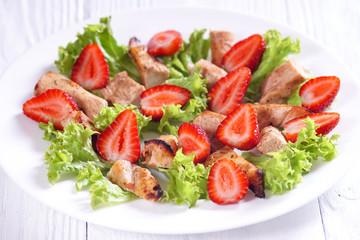 Chicken salad and strawberries on a white table