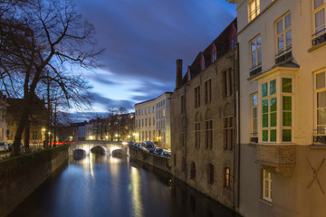 Fototapeta na wymiar Bruges canal view with bridge, tree and houses at blue hour, Belgium