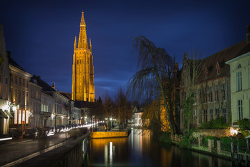 Bruges night scene with canal and church at blue hour, Belgium