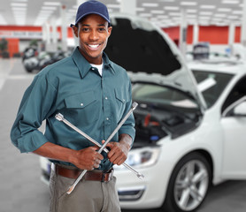Smiling car mechanic in auto repair service. 