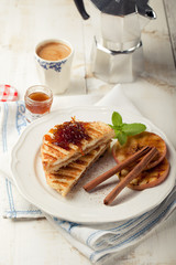 French toasts with orange marmalade, grilled apples and cinnamon sticks.