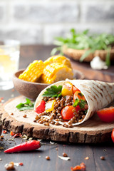 Vegan tortilla wrap, roll with grilled vegetabes, lentil, corn cob.