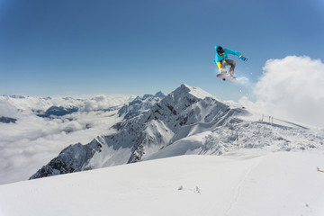 Naklejka na ściany i meble Flying snowboarder on mountains, extreme sport