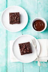 Chocolate brownie, cake, white plate on a turquoise wooden background