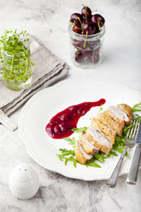 Duck breast meat with fresh salad, arugula and cherry sauce.