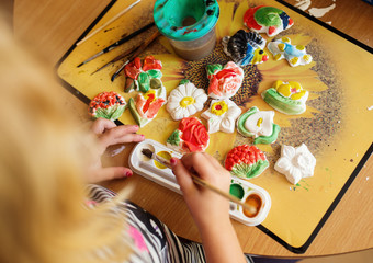 Child painting a ceramic pottery model