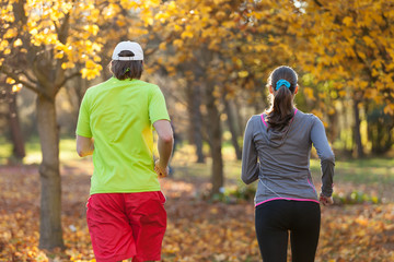 Fototapeta na wymiar Young couple running in autumn season