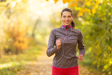 Female fitness model training outside and running.