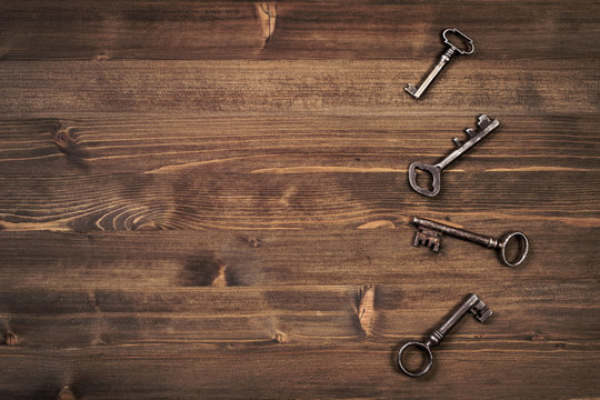 Old keys from right side of wooden background
