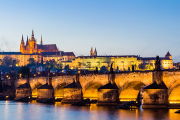 Fototapeta premium The Prague Castle (built in gothic style) and Charles Bridge are the symbols of Czech capital, built in medieval times. Twilight view of Prague