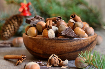 Fototapeta na wymiar Hazelnuts with chocolate and cinnamon in a wooden bowl.