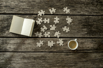 Top view of puzzle pieces scattered on a rustic wooden study des