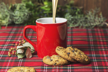Red cup of coffee, vanilla cookies with chocolate chips