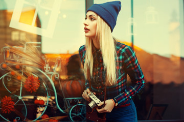 Portrait of beautiful young playful hipster woman with old retro camera. Model looking aside. City lifestyle.  Toned - obrazy, fototapety, plakaty