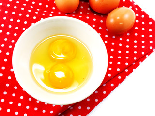 broken eggshells with egg yolks in ceramic bowl