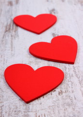 Valentine red hearts on old wooden white table, symbol of love