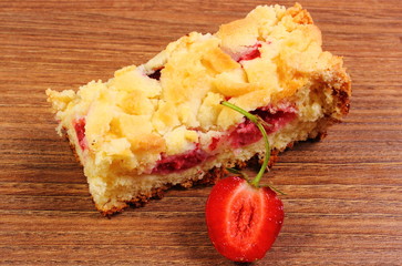 Fresh baked yeast cake with strawberries on wooden table