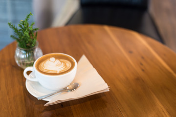 Hot art Latte Coffee in a cup on wooden table