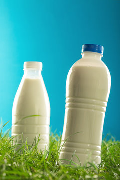 Milk Bottles on the grass isolated on blue background