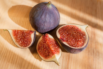 Fresh figs, whole and sliced on a light wood