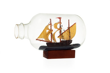 Old sailboat in glass bottle isolated over white background