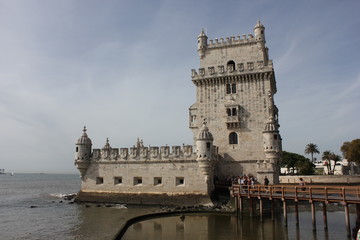 Fototapeta na wymiar Belem Tower of Lisbon, Unesco world heritage, with people on the bridge