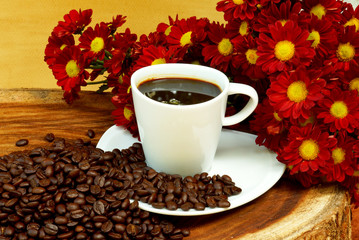 Coffee cup and beans on a wood background.