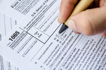 Fototapeta premium Person completing 1065 tax form