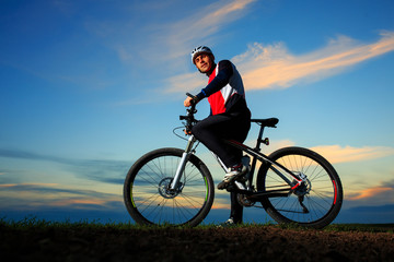 Fototapeta na wymiar young adult cyclist riding mountain bike in the countryside
