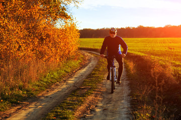 Obraz premium young adult cyclist riding mountain bike in the countryside