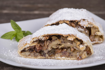 Slice of an apple strudel on a white plate