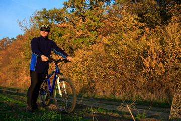 Obraz premium young adult cyclist riding mountain bike in the countryside