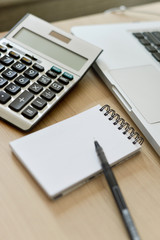 Blank Note Pad, Calculator, Computer, Pen on the Table