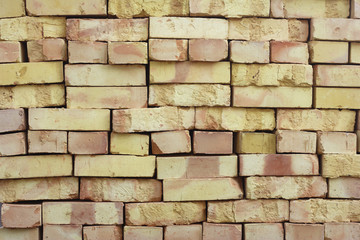 Wall of stacked bricks. New bricks made of clay, manufacturing quality is poor.