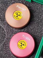 Two specialist containers with warning sticker and engraving containing radioactive isotopes...