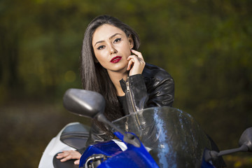 Obraz na płótnie Canvas Beautiful Biker girl on a motorcycle