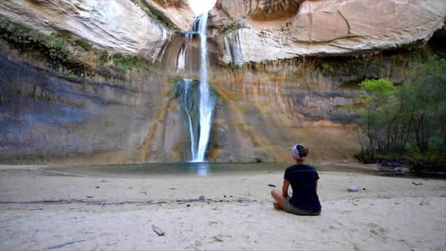 Woman Sitting in front of the Lower Calf Creek Falls, Calf Creek, Grand Staircase-Escalante National Monument, south Utah, USA