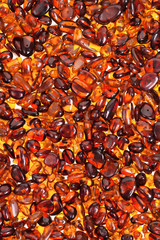 Red amber stones lie on a flat surface.