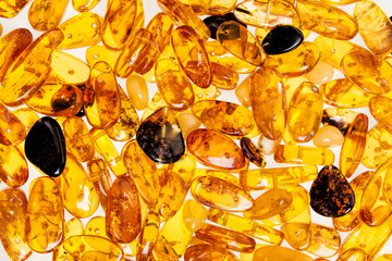 Yellow amber stones lie on a flat surface.